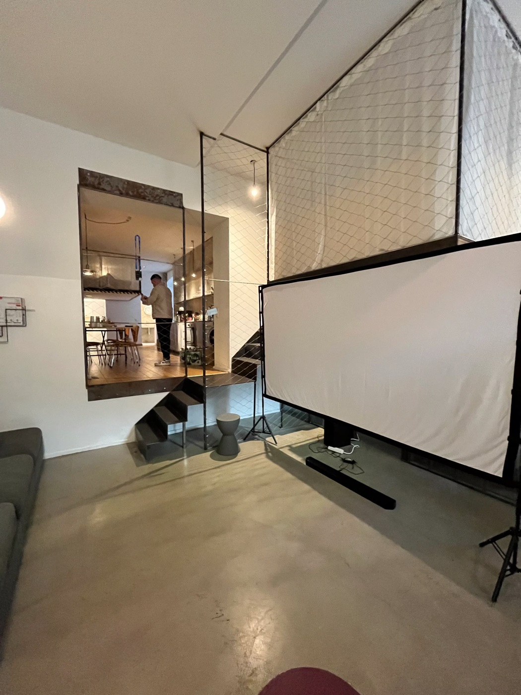 Der Raum vor dem Start: Leinwand, Sofa und die Galerie im ersten Stock